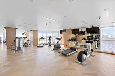 a gym with several treadmills and exercise bikes at StoneTree - Stylish Studio Apartment in Damac Hills in Dubai