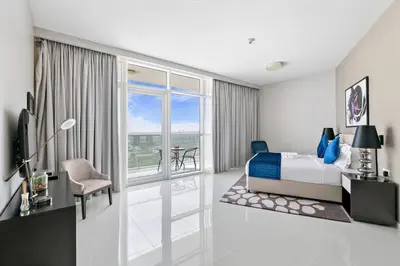 a hotel room with a bed and a balcony at StoneTree - Stylish Studio Apartment in Damac Hills in Dubai