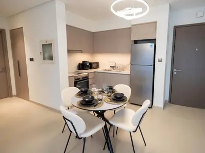 a kitchen with a table with chairs and a refrigerator at MH - Act One Act Two - DownTown - 1BHK - REF505 in Dubai