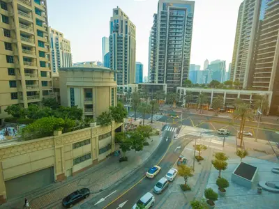 a city with cars on a street with tall buildings at MH - Act One Act Two - DownTown - 1BHK - REF505 in Dubai