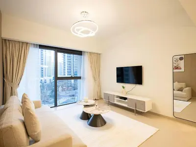 a white living room with a couch and a tv at MH - ACT TOWER - Downtown -1Bedroom Apartment - REF504 in Dubai