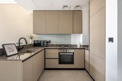 a kitchen with white cabinets and a sink at GuestReady - Majestic canal and Burj Khalifa view in Dubai