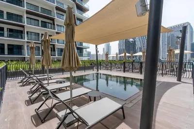 a pool with chairs and umbrellas on a building at GuestReady - Majestic canal and Burj Khalifa view in Dubai