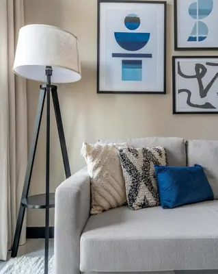 a lamp sitting next to a couch in a living room at GuestReady - Majestic canal and Burj Khalifa view in Dubai