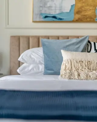 a bed with blue and white pillows at GuestReady - Modernity elegance in Dubai Marina in Dubai