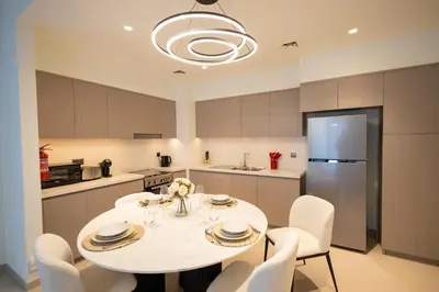 a kitchen with a table and chairs and a refrigerator at MH - ACT Tower -Downtown- 2Bedrooms - REF 408 in Dubai