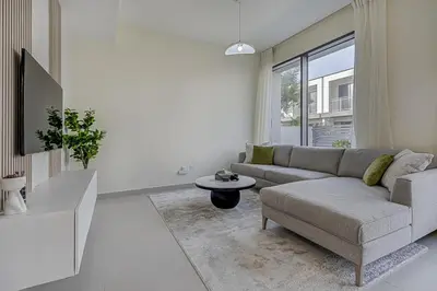 a living room with a couch and a table at Brand New Luxurious 4BR & Maid Room Townhouse in Dubail Hill Estate in Dubai
