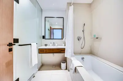 a white bathroom with a tub and a sink at Elegant 3BD family home in Marina Vida Residence in Dubai