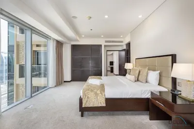 a bedroom with a large bed and a desk and windows at Marina Canal Views 2BR Unit Next to Marina Mall, The Address Residences, Dubai Marina by Deluxe Holiday Homes in Dubai