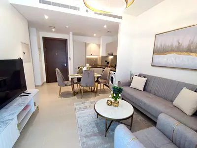 a living room with a couch and a table at New 1 bedroom in Sobha - Community View in Dubai