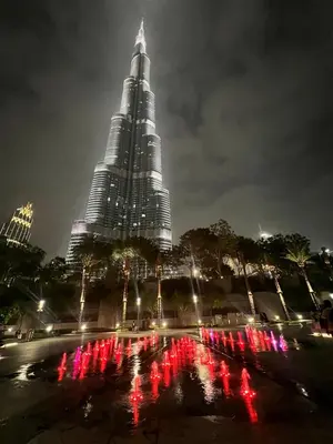 a tall skyscraper with a fountain in front of a large building at 8 Boulevard Walk 'Heart of Downtown' in Dubai