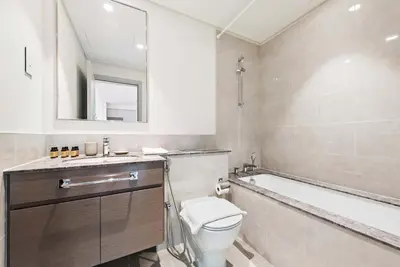 a bathroom with a toilet and a tub and a sink at Silkhaus awesome 1BDR in Opera District in Dubai