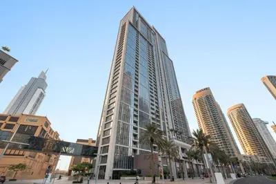 a tall building with palm trees in a city at Silkhaus awesome 1BDR in Opera District in Dubai