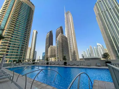 a large swimming pool in a city with tall buildings at Silkhaus awesome 1BDR in Opera District in Dubai