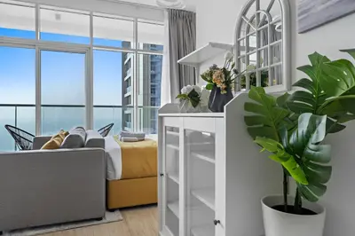 a living room with a bed and a table with a plant at StoneTree - Best Rate Studio in Dubai Marina in Dubai