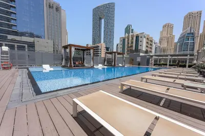 a large swimming pool with benches in a city at StoneTree - Best Rate Studio in Dubai Marina in Dubai
