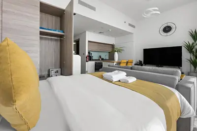 a bedroom with a large white bed and a couch at StoneTree - Best Rate Studio in Dubai Marina in Dubai