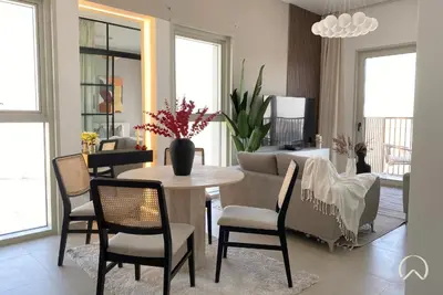 a living room with a table and chairs and a couch at Oraya - Apt. With Skyline and Garden View Along With City in Dubai