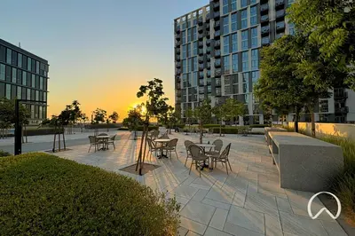a patio with tables and chairs in a city at Oraya - Apt. With Skyline and Garden View Along With City in Dubai