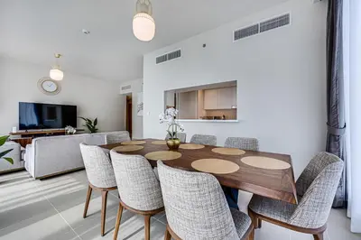 a dining room with a wooden table and chairs at Comfy family 3BD apartment in Dubai Creek Harbour in Dubai