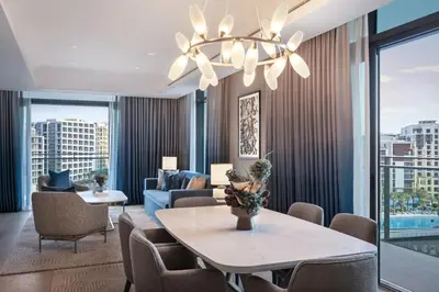 a living room with a table and chairs at Palace Dubai Creek Harbour in Dubai