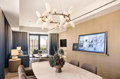 a living room with a dining table and a chandelier at Palace Dubai Creek Harbour in Dubai