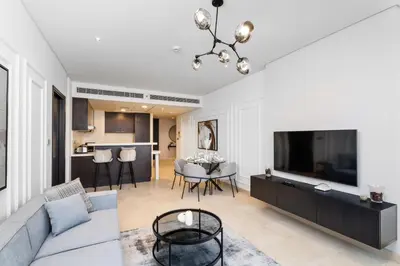 a living room with a couch and a tv at Nasma Luxury Stays - Elegant 1BR With Stunning View of Park Avenue in Dubai