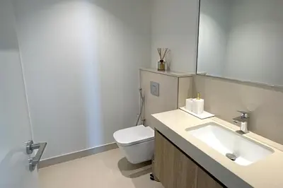a bathroom with a sink and a toilet and a mirror at RH - Beautiful Burj Khalifa View, 03BR with Maid's Room, 7 mins walk to Dubai Mall in Dubai