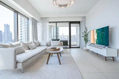 a living room with a white couch and a tv at RH - Beautiful Burj Khalifa View, 03BR with Maid's Room, 7 mins walk to Dubai Mall in Dubai