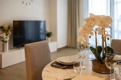 a dining room table with a table centerpiece with white flowers at Splendid brand new 1BD apartment near the beach in Dubai