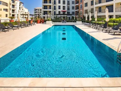 a swimming pool with blue water in a building at Splendid brand new 1BD apartment near the beach in Dubai