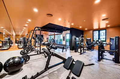 a gym with several treadmills and exercise bikes at Splendid brand new 1BD apartment near the beach in Dubai