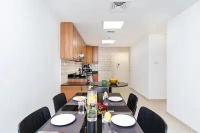 a dining room with a table and chairs and a kitchen at Vibrant - Prime Location Dubai Marina - Near Metro in Dubai