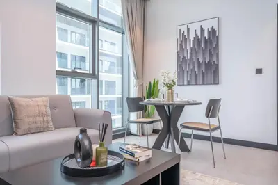 a living room with a couch and a table at Pristine 1 Bedroom - Business Bay in Dubai