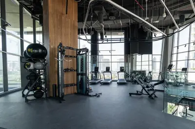 a gym with cardio equipment in a large room with windows at Pristine 1 Bedroom - Business Bay in Dubai