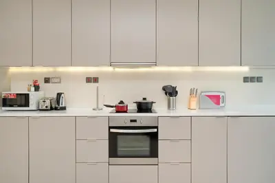 a white kitchen with white cabinets and appliances at Comfortable 2 Bed - Near Marina Mall in Dubai
