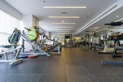 a gym with several treadmills and machines at Comfortable 2 Bed - Near Marina Mall in Dubai
