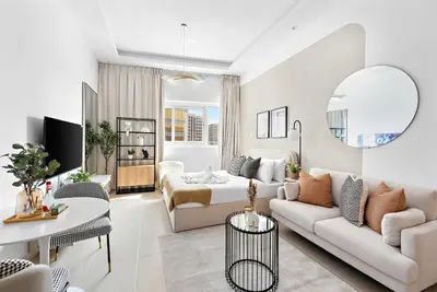 a white living room with a couch and a table at Silkhaus New studio in Silicon Oasis ASB Tower in Dubai
