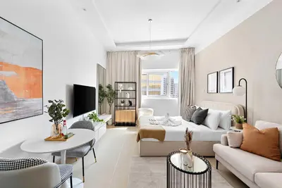 a white living room with a couch and a table at Silkhaus New studio in Silicon Oasis ASB Tower in Dubai
