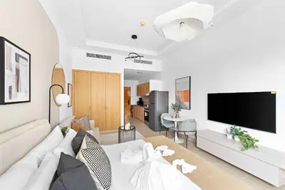 a living room with a white couch and a flat screen tv at Silkhaus New studio in Silicon Oasis ASB Tower in Dubai