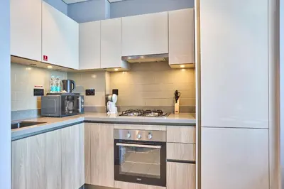 a kitchen with white cabinets and a stove top oven at STAY BY LATINEM Luxury 1BR Holiday Home W 2709 Near Burj Khalifa in Dubai