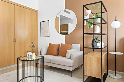 a living room with a couch and a mirror at Silkhaus New Studio in ASB Tower Walking distance to mall in Dubai