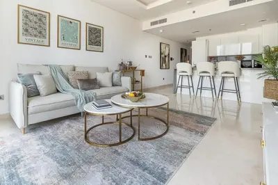 a living room with a couch and a table at Frank Porter - The Sterling by Omniyat in Dubai