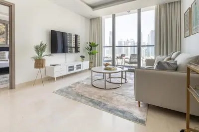 a living room with a couch and a table at Frank Porter - The Sterling by Omniyat in Dubai