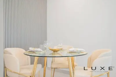 a dining room with a glass table and chairs at Luxe - Relax in Style Scandi 1BR with Sofa Bed in Dubai