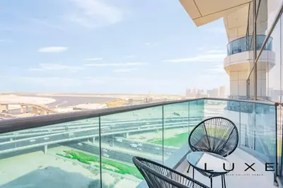 a balcony with a table and chairs on a building at Luxe - Relax in Style Scandi 1BR with Sofa Bed in Dubai