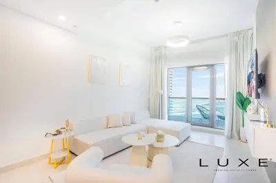 a living room with white furniture and a large window at Luxe - Relax in Style Scandi 1BR with Sofa Bed in Dubai