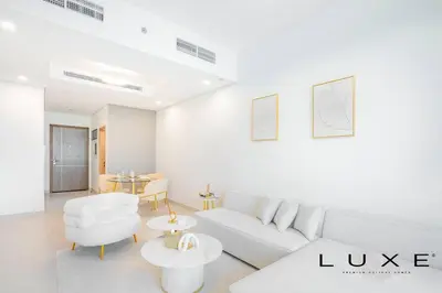 a white living room with a white couch and tables at Luxe - Relax in Style Scandi 1BR with Sofa Bed in Dubai