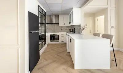 a kitchen with white cabinets and a black refrigerator at Luxury 1 bedroom with beautiful marina view! in Dubai