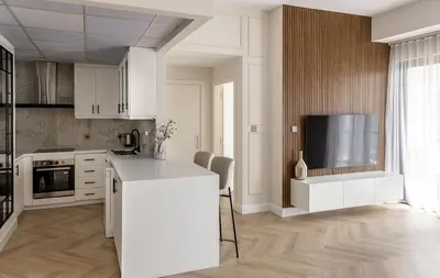 a kitchen with white cabinets and a flat screen tv at Luxury 1 bedroom with beautiful marina view! in Dubai